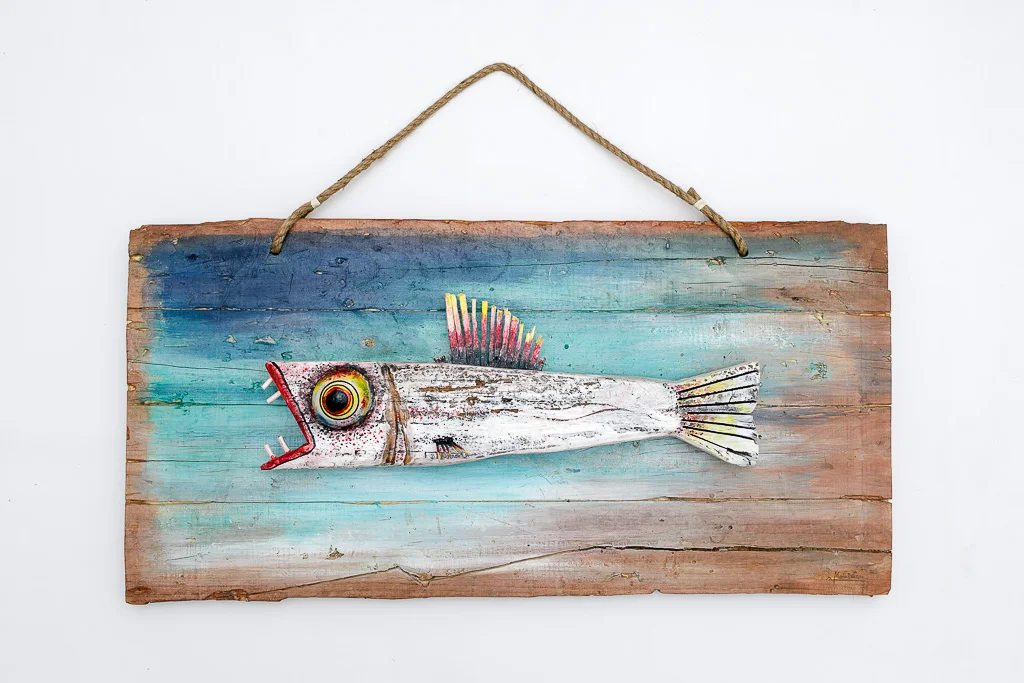 Original 81cm hand-carved wood fish sculpture with neon accents and riverbank blue background by Mario Diaz Art.