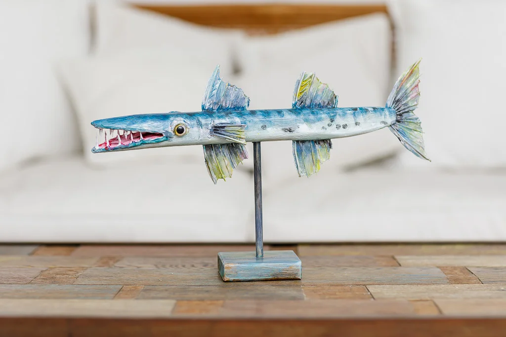 Original 38cm hand-carved wood barracuda sculpture on minimalist metal stand, iridescent blue and silver finish, handcrafted by Mario Diaz Art.